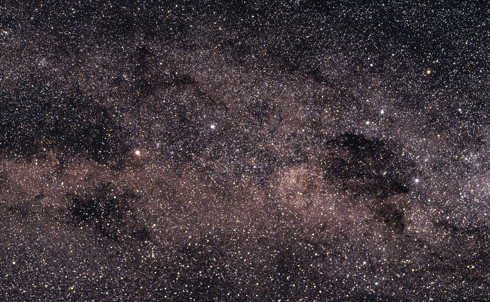 Dense southern Milky Way star field with two bright stars at left and the Southern Cross at right.