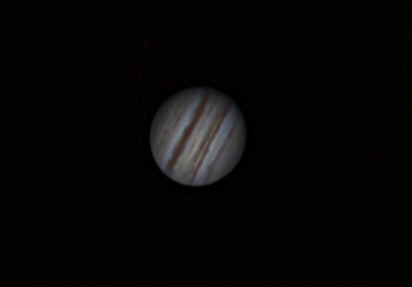 Jupiter on a black background showing two dark brown belts across a pale disc.