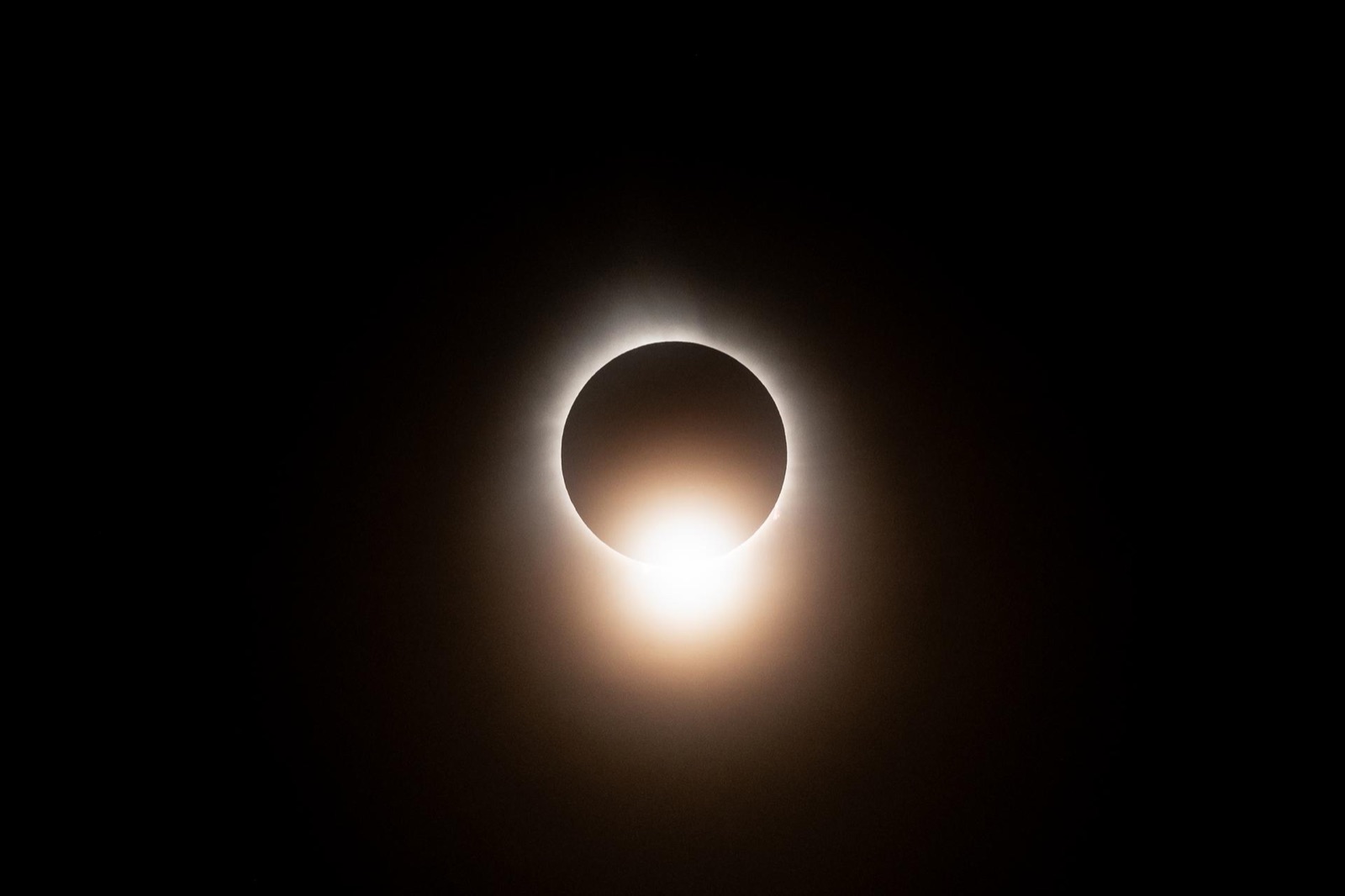 A bright bead of sunlight on the edge of the dark Moon with the inner corona around it.