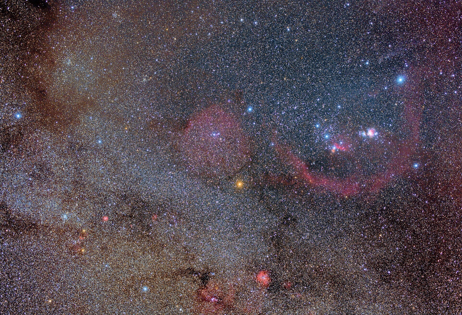 Wide view of Orion with red nebulae including Barnard's Loop, taken with a 40 mm camera lens