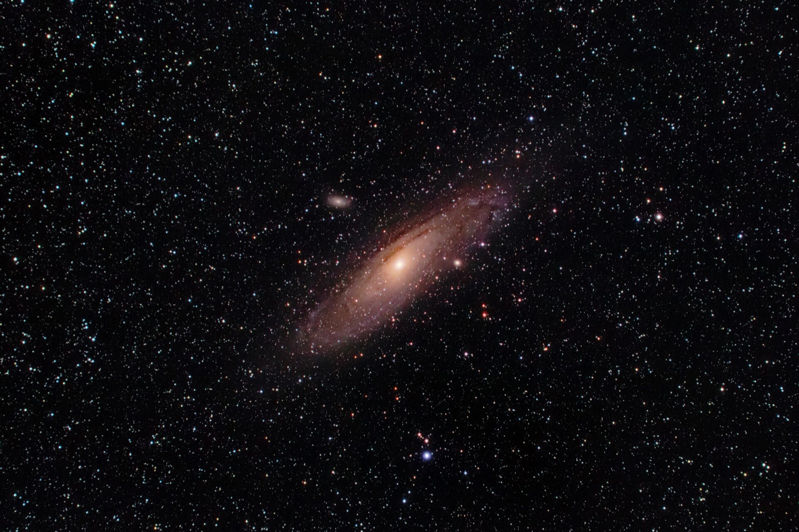 Andromeda Galaxy with its two companion galaxies in a field of stars, taken with a 135 mm lens